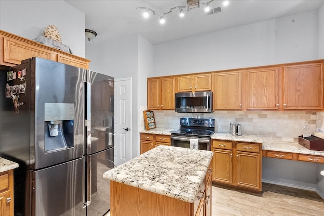 405 Londonderry Ln, Mansfield, TX 76063 - kitchen with visible vents, light wood-style floors, light stone countertops, decorative backsplash, and appliances with stainless steel finishes