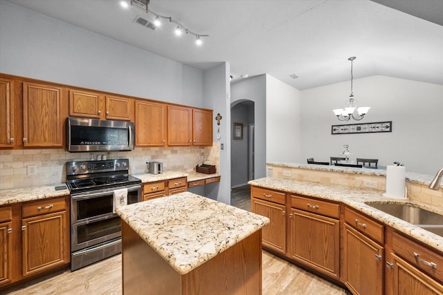 405 Londonderry Ln, Mansfield, TX 76063 - kitchen with arched walkways, brown cabinetry, stainless steel appliances, and a sink