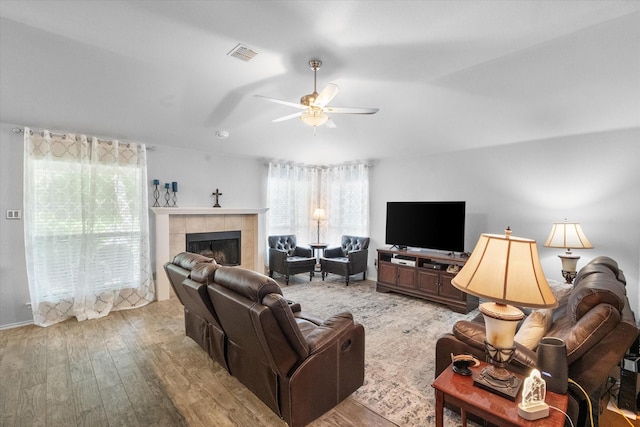 405 Londonderry Ln, Mansfield, TX 76063 - living area featuring a tile fireplace, ceiling fan, wood finished floors, and visible vents