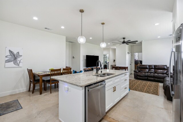 kitchen with appliances with stainless steel finishes, a sink, finished concrete flooring, open floor plan, and white cabinetry