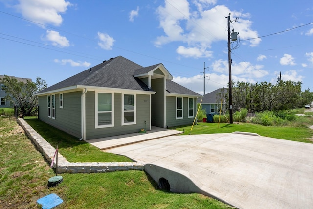 rear view of house with a yard and a shingled roof