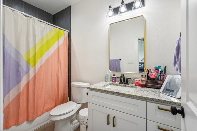 full bath with shower / tub combo, vanity, and toilet