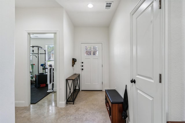 entryway with baseboards, finished concrete floors, visible vents, and recessed lighting