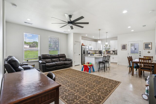 living room with recessed lighting, visible vents, a ceiling fan, and baseboards
