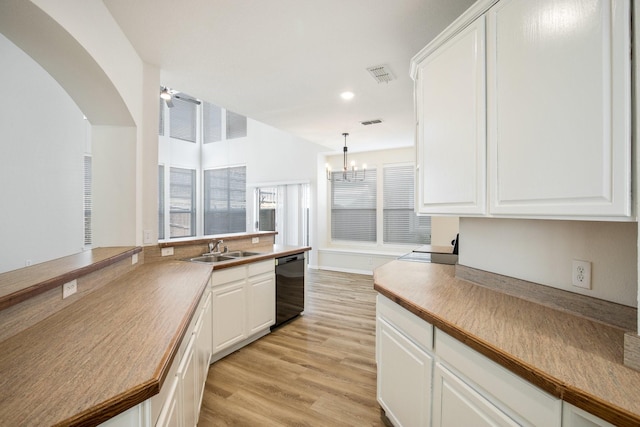 kitchen featuring white cabinets, dishwasher, visible vents, a sink, and light wood-style flooring