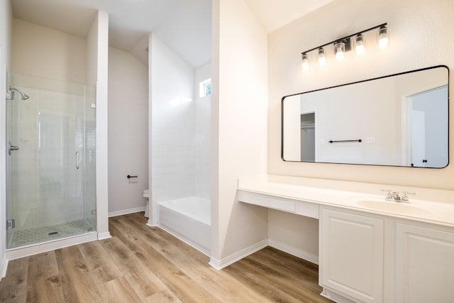 full bath featuring baseboards, toilet, wood finished floors, and a stall shower