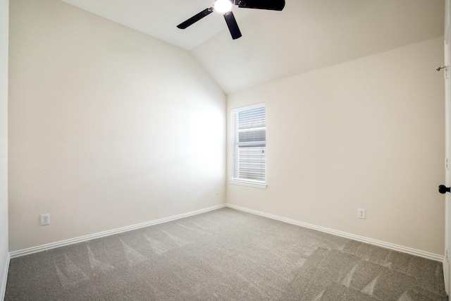 spare room with lofted ceiling, baseboards, a ceiling fan, and carpet flooring