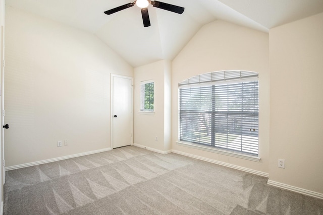 empty room with vaulted ceiling, carpet, a ceiling fan, and baseboards