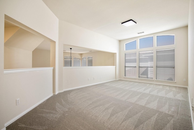 empty room with baseboards, carpet flooring, and visible vents