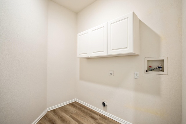 clothes washing area with baseboards, hookup for a washing machine, wood finished floors, cabinet space, and electric dryer hookup