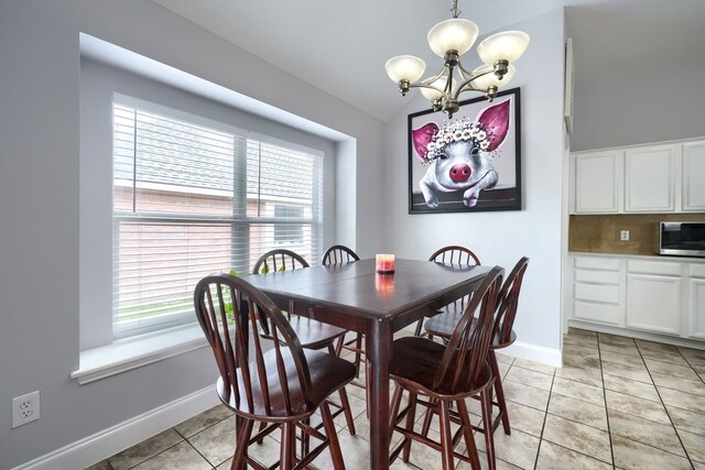 dining space featuring a healthy amount of sunlight, a notable chandelier, and vaulted ceiling