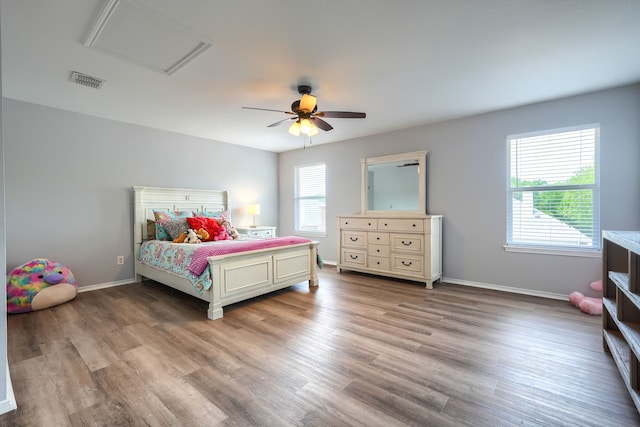 bedroom featuring visible vents, light wood-style flooring, multiple windows, and baseboards
