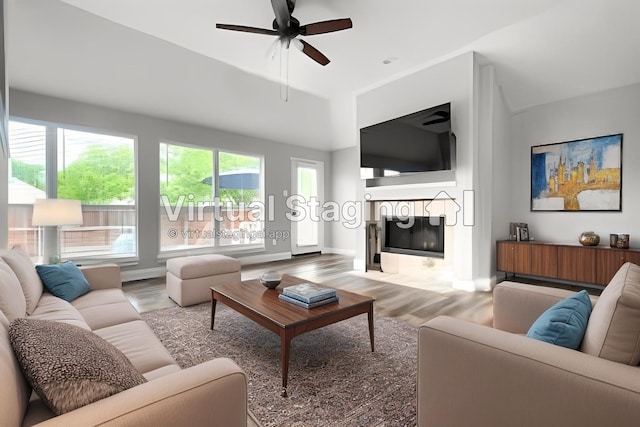 living room featuring a fireplace, wood finished floors, ceiling fan, and baseboards