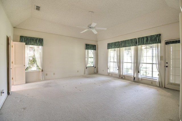 unfurnished room with ceiling fan, vaulted ceiling, visible vents, and carpet