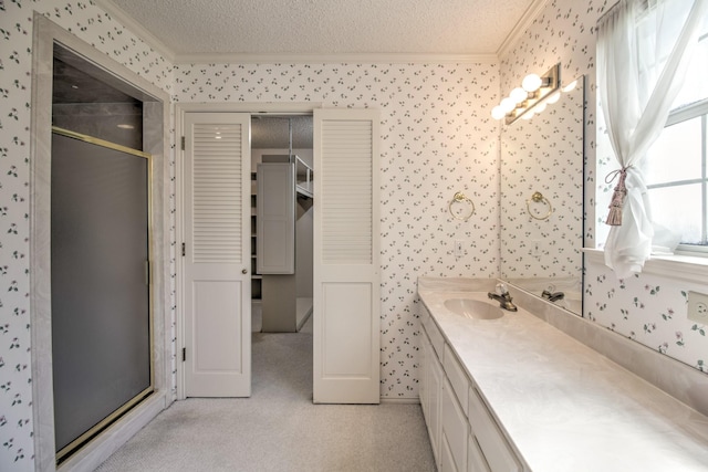 full bath with wallpapered walls, vanity, a shower stall, and crown molding