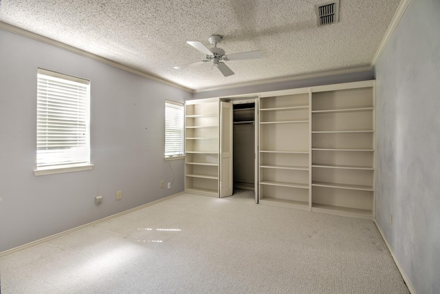 unfurnished bedroom featuring carpet floors, crown molding, a textured ceiling, and visible vents