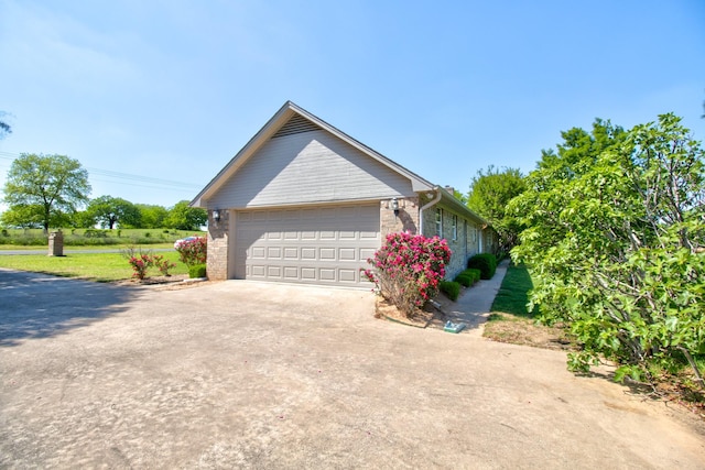 view of side of property featuring driveway and a garage