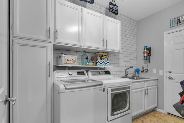 laundry room with washing machine and dryer, a sink, light tile patterned floors, and cabinet space