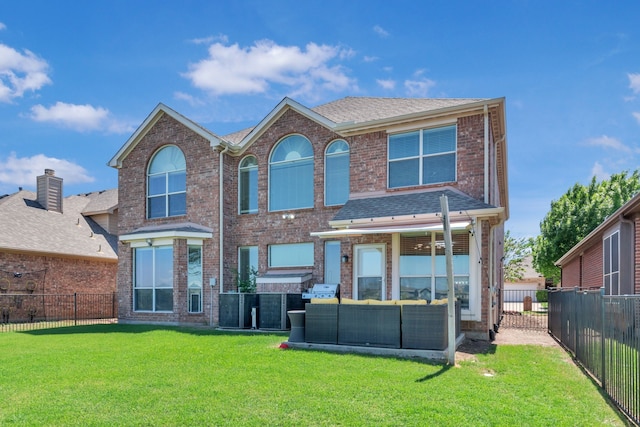 back of house with brick siding, a yard, a fenced backyard, and an outdoor living space