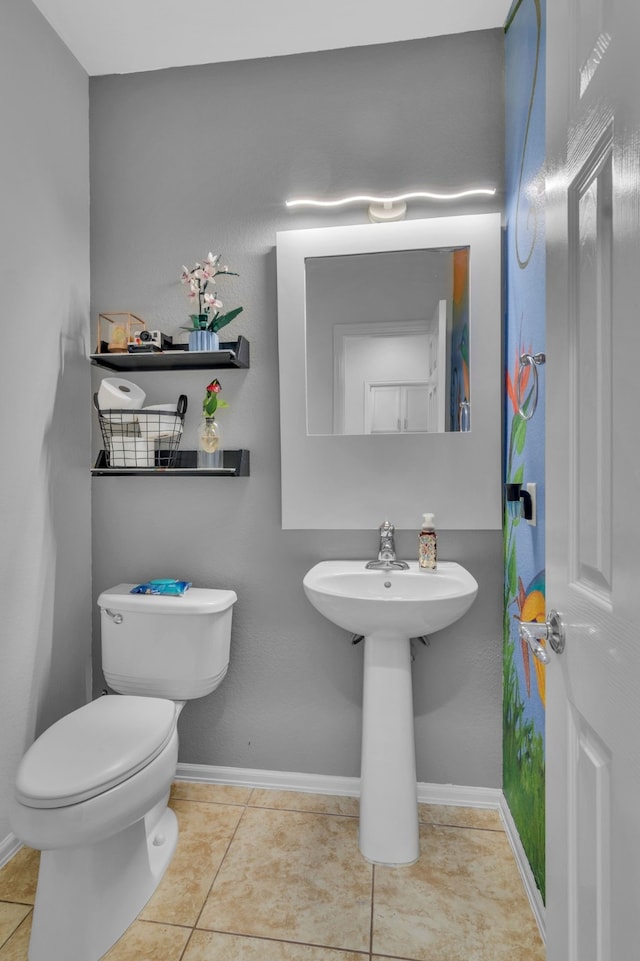 half bathroom featuring toilet, tile patterned flooring, and baseboards