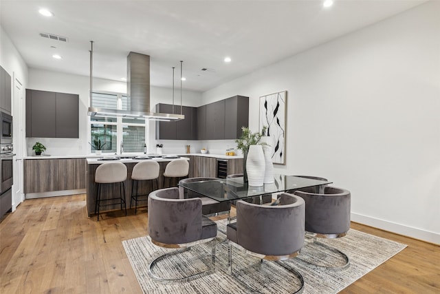 3040 Chimes St, Dallas, TX 75219 - dining space featuring light wood finished floors, recessed lighting, baseboards, and beverage cooler