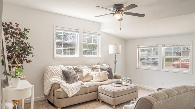living room with vaulted ceiling, a ceiling fan, baseboards, and light colored carpet