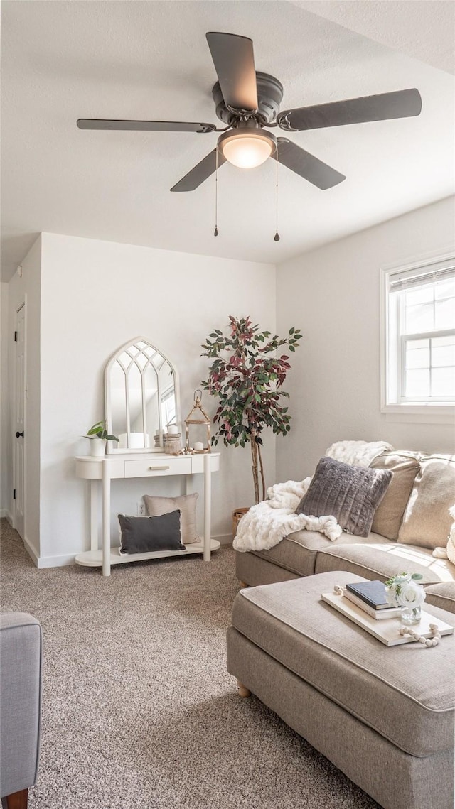living room with carpet flooring, baseboards, and a ceiling fan