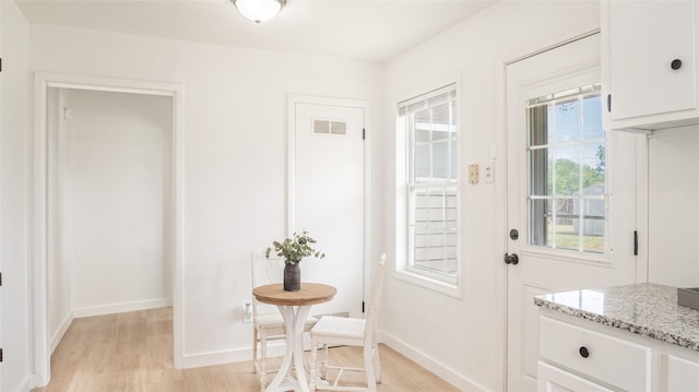 doorway to outside featuring light wood-style floors, visible vents, and baseboards