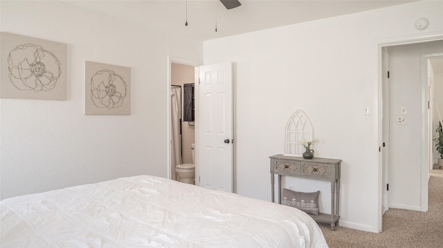 carpeted bedroom with baseboards, connected bathroom, and ceiling fan
