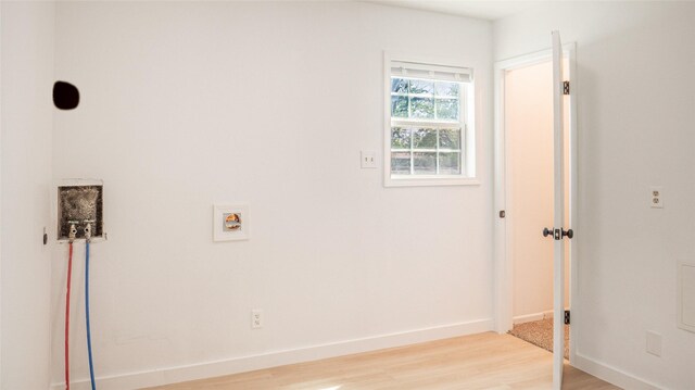 laundry area featuring washer hookup, light wood-style flooring, baseboards, and laundry area