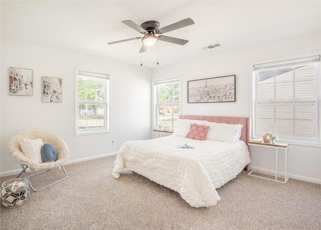 bedroom with baseboards, visible vents, carpet flooring, and multiple windows