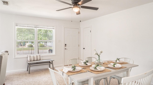 carpeted dining space with baseboards, visible vents, and ceiling fan