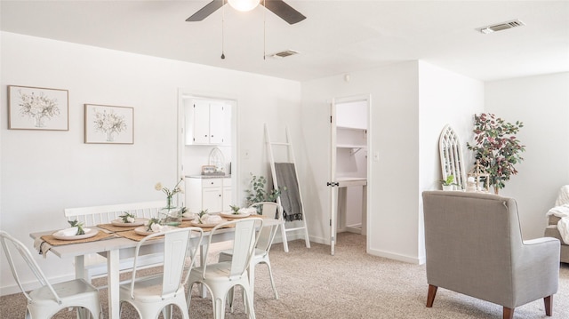 dining space with visible vents, a ceiling fan, baseboards, and light carpet