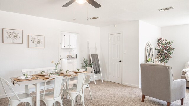 dining space featuring ceiling fan, light carpet, and visible vents