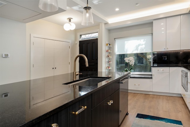 7404 W NW Hwy Unit 9, Dallas, TX 75225 - kitchen with dark stone counters, white cabinetry, a sink, and tasteful backsplash