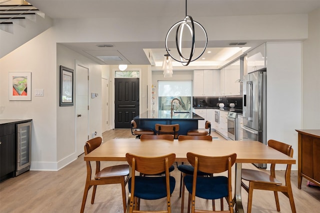 7404 W NW Hwy Unit 9, Dallas, TX 75225 - dining area featuring wine cooler, baseboards, light wood finished floors, and visible vents