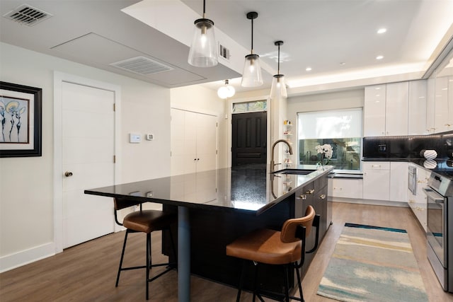 7404 W NW Hwy Unit 9, Dallas, TX 75225 - kitchen featuring light wood-type flooring, a sink, white cabinetry, and visible vents