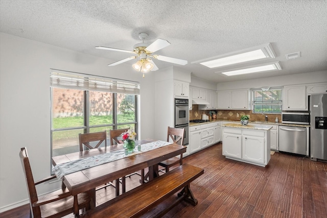 kitchen with white cabinets, stainless steel appliances, a sink, and a textured ceiling