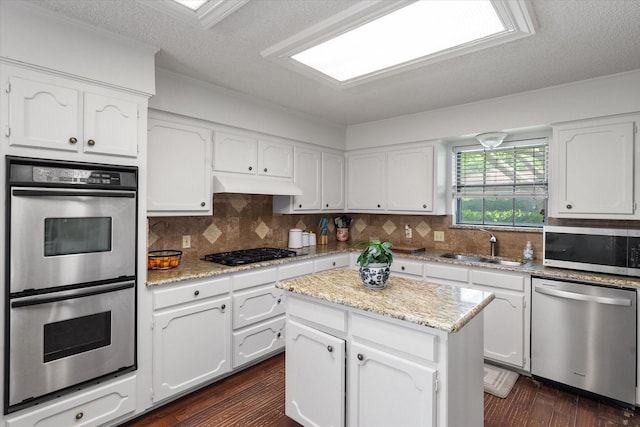 kitchen featuring white cabinets, appliances with stainless steel finishes, a sink, and a textured ceiling