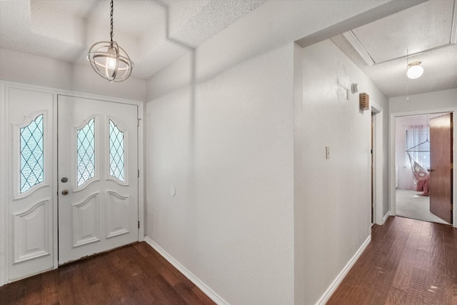 foyer entrance featuring dark wood finished floors, a healthy amount of sunlight, and baseboards