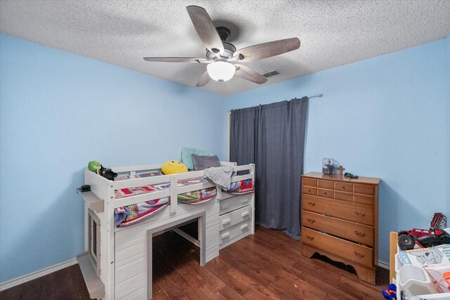 bedroom with a textured ceiling, wood finished floors, visible vents, and a ceiling fan