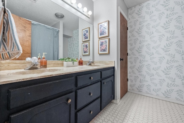 bathroom with a shower with curtain, double vanity, baseboards, and a sink