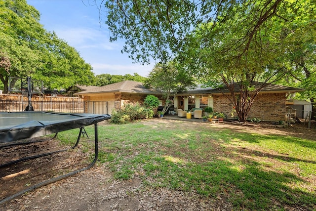 view of yard with a garage, a pool, and fence