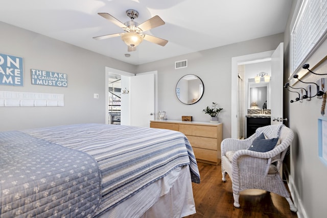 bedroom with wood finished floors, visible vents, a ceiling fan, and connected bathroom