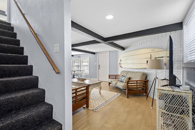 living area with stairway, light wood-type flooring, baseboards, beam ceiling, and recessed lighting