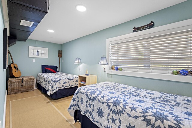 bedroom featuring recessed lighting, wood finished floors, visible vents, and multiple windows