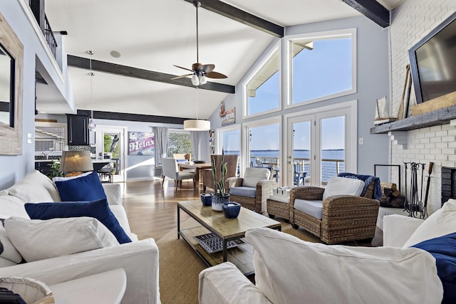 living room with a water view, beamed ceiling, wood finished floors, ceiling fan, and high vaulted ceiling