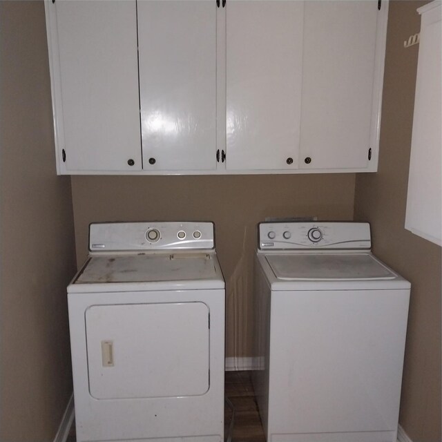 washroom with separate washer and dryer, baseboards, and cabinet space