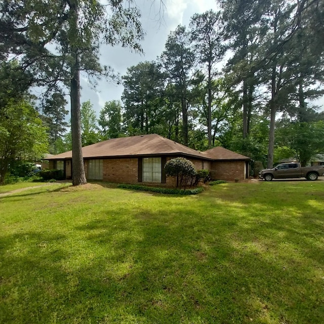 view of home's exterior with brick siding and a lawn