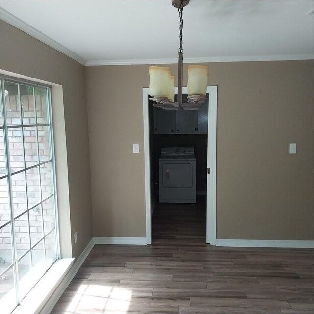 unfurnished dining area featuring an inviting chandelier, washer / clothes dryer, wood finished floors, and baseboards